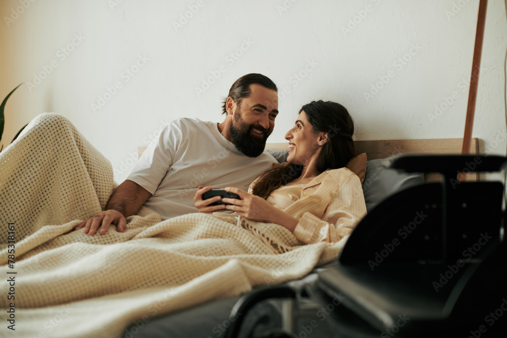 beautiful joyous woman with mobility disability lying in bed next to her bearded loving husband beautiful joyous woman with mobility disability lying in bed next to her bearded loving husband