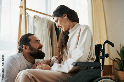 attractive cheerful man spending time with his beautiful disabled wife while in bedroom at home