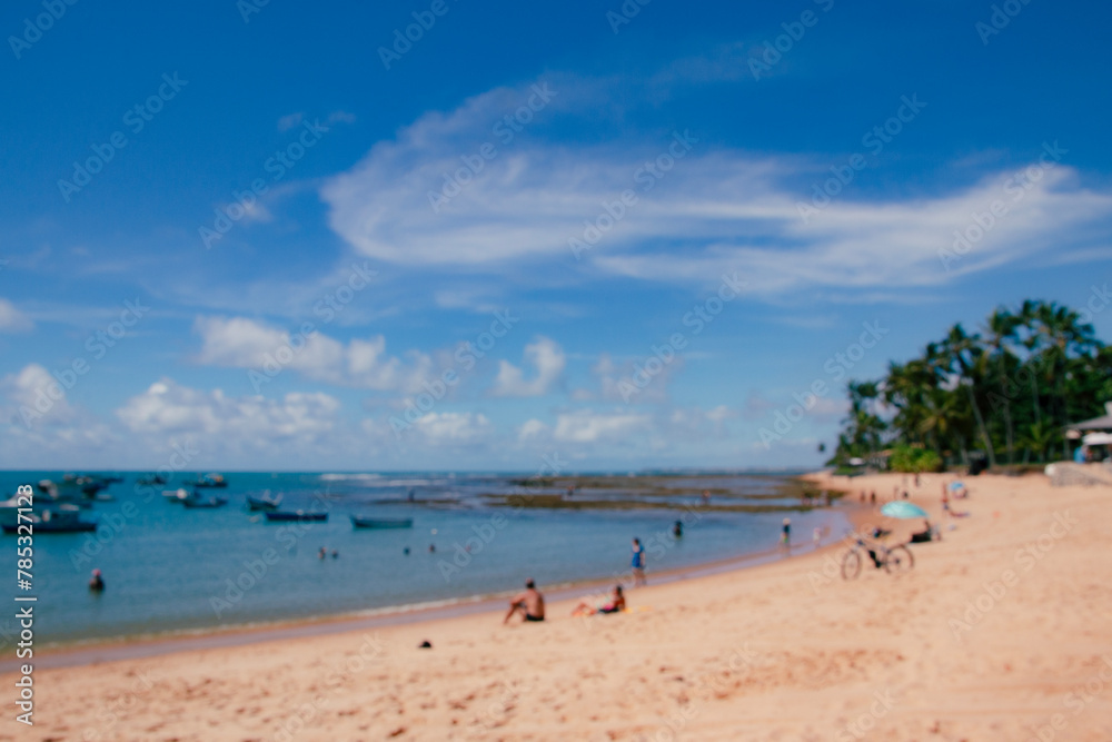 Blurred image of people enjoying the beach in summer with blue sky