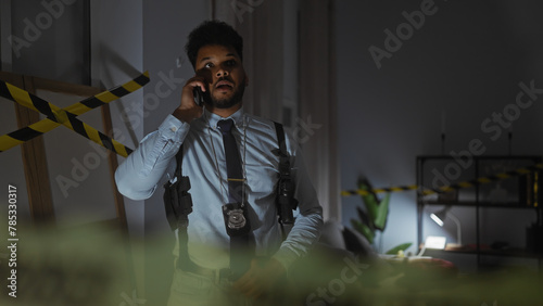 African american detective in a police station making a phone call, surrounded by dim lighting and caution tape.