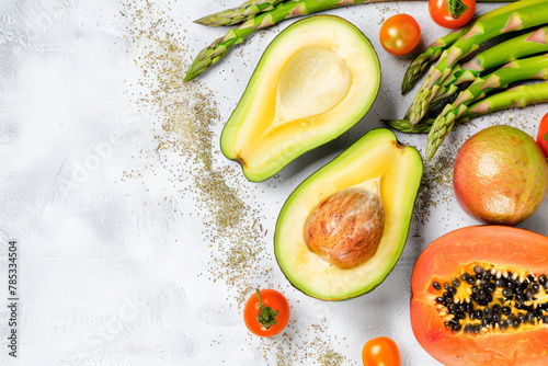 Clean-eating food frame with copy space. Top view of papaya, avocado, tomato, grape, asparagus.