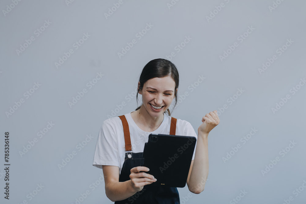 .Cheerful beautiful Asian woman wearing jeans overalls with excited doing winner gesture with arms raised isolated on white background. .Cheerful beautiful Asian woman wearing jeans overalls with excited doing winner gesture with arms raised isolated on white background.