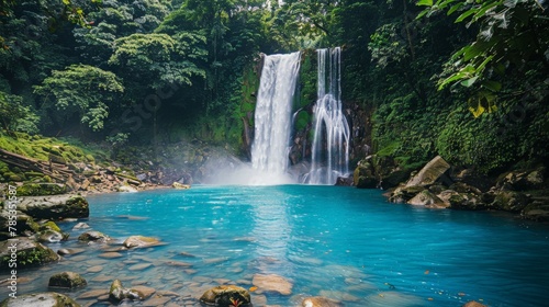 A majestic waterfall cascading into a tranquil pool in a lush forest