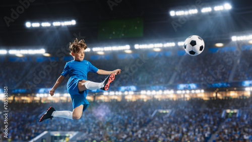Aesthetic Shot Of Athletic Child Soccer Football Player Jumping And Kicking Ball Mid-Air On Stadium WIth Crowd Cheering. Young Boy Scoring Winning Goal on Junior World Championship Tournament Match. © Gorodenkoff