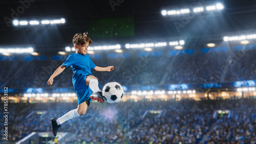 Aesthetic Shot Of Athletic Child Soccer Football Player Jumping And Kicking Ball Mid-Air On Stadium WIth Crowd Cheering. Young Boy Scoring a Goal on Junior World Championship Tournament Match. © Gorodenkoff