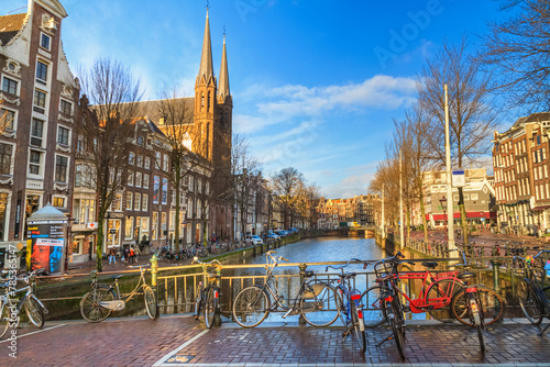 Cityscape on a sunny winter day - view of the water channel from the bridge in the historic center of Amsterdam, the Netherlands