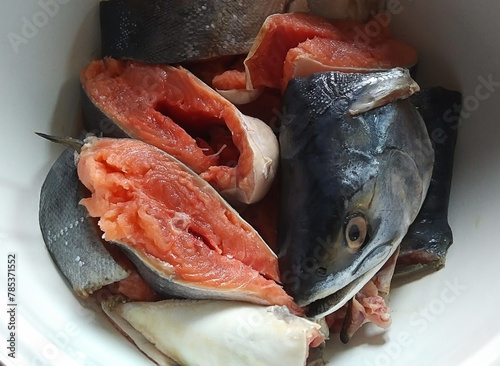 Red raw fish cut into pieces close-up.