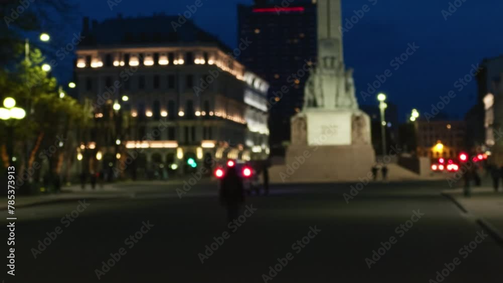Cityscape at night with a blurred statue in the foreground Cityscape at night with a blurred statue in the foreground