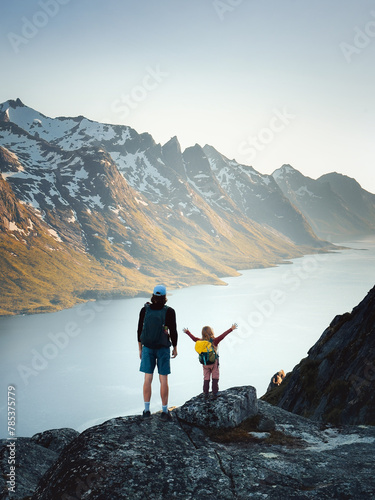 Family father and child hiking in mountains of Norway together exploring Kvaloya island adventure healthy lifestyle outdoor active vacations dad with daughter enjoying fjord view