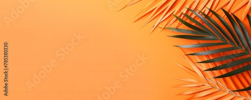 Palm leaf on an orange background with copy space for text or design. A flat lay  top view. A summer vacation concept