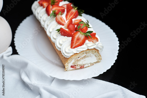 sponge roll with cream, decorated with fresh strawberries