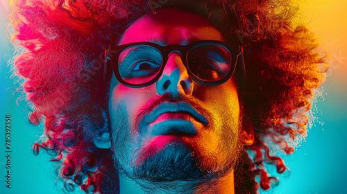 A person with curly hair bathed in dramatic neon red and blue lights, creating a striking and artistic portrait.