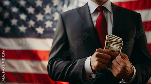 Businessman holding money in front of american flag photo