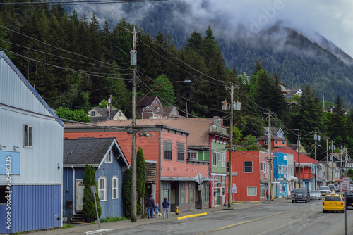 Historic old wooden houses facades along Creek in downtown Ketchikan, Alaska with colorful buildings, fisherman homes, marina with boats and tourist traffic on road popular cruise ship destination photo