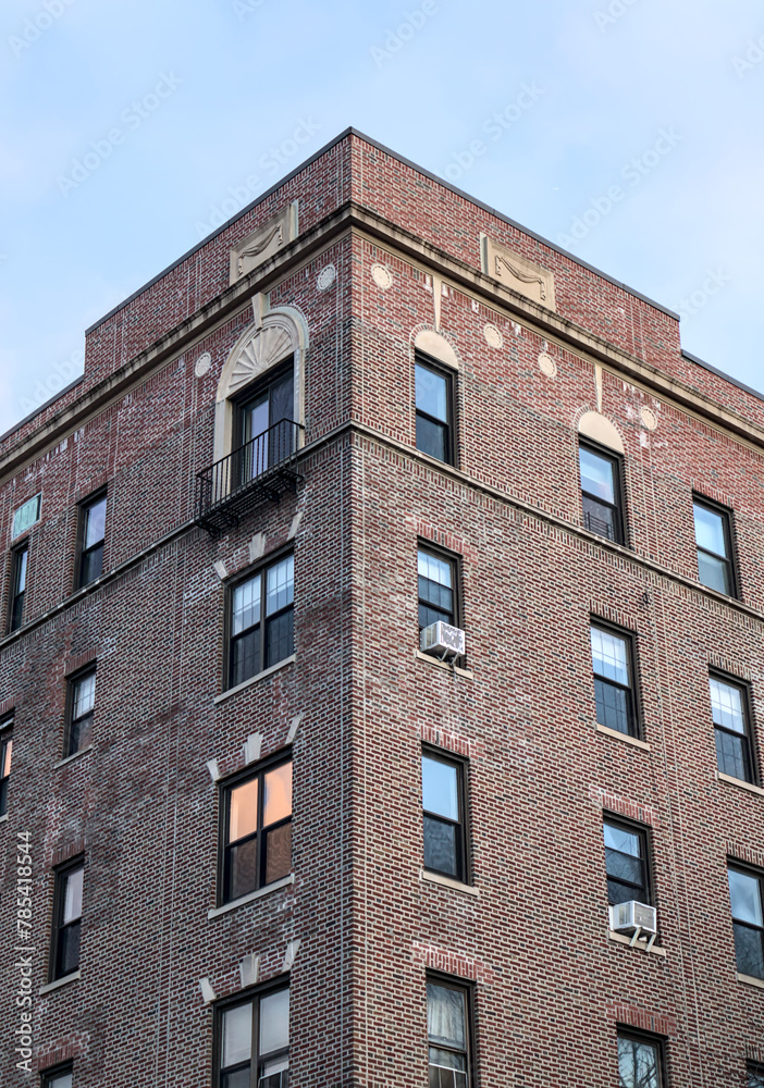 top of typical pre-war historic apartment building in crown heights brooklyn new york city (brick home with apartment windows and decorative cornices circling window) detail photo real estate housing