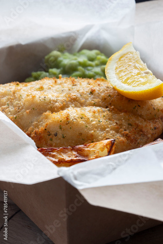 Fish and chips takeaway with mush peas and lemon. Biodegradable plastic free eco friendly takeaway cardboard box.