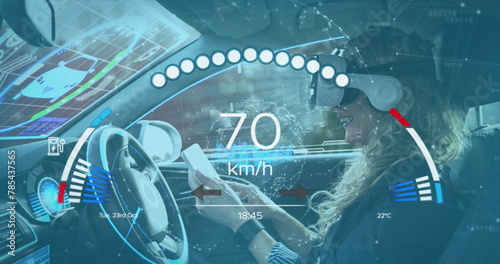 Image of speedometer over caucasian woma nin vr headset driving electric car photo
