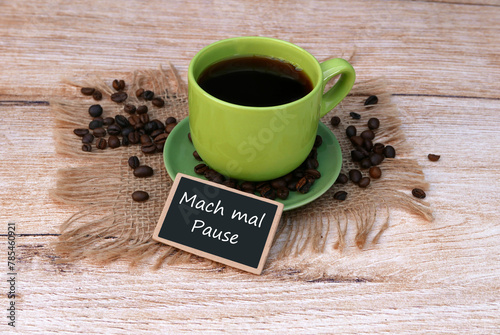 Foto Vor einer Tasse Kaffee steht ein Schild mit der Aufschrift mach mal Pause