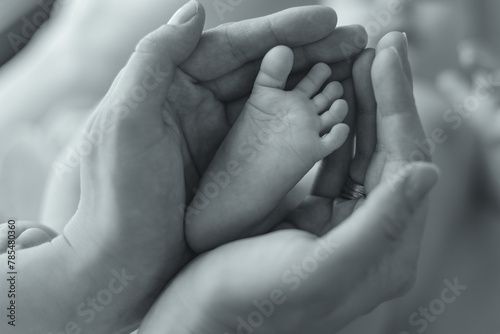 small foot of a newborn baby in mother's hands, mother's day concept
