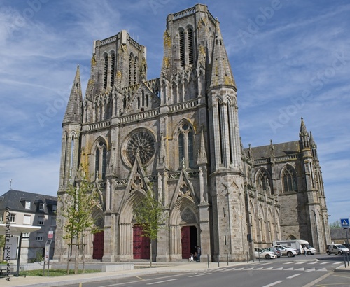 Avranches, France - Apr 13, 2024: Notre-Dame-des-Champs Cathedral. People walking in Avranches. Streets and buildings. Lifestyle in the urban area. Sunny spring day. Selective focus photo