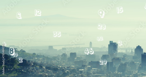 Image of numbers over fog covered aerial view of modern cityscape in background