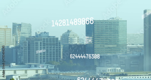 Image of changing numbers over buildings against clear sky