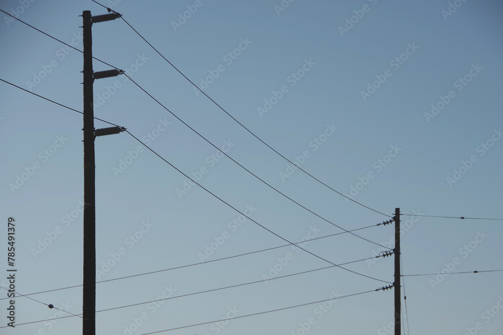 Electricity distribution pylons and power lines under blue sky Electricity distribution pylons and power lines under blue sky