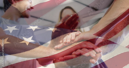 Image of flag of united states of america over caucasian friends stacking hands