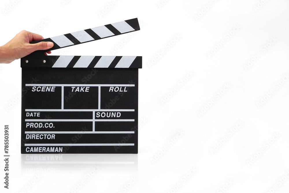 Fototapeta premium Hand holding a clapperboard or movie slate black color on white background. Cinema industry, video production and film concept..