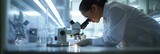 In a high-tech lab, a scientist studies a specimen under a microscope amidst scientific equipment