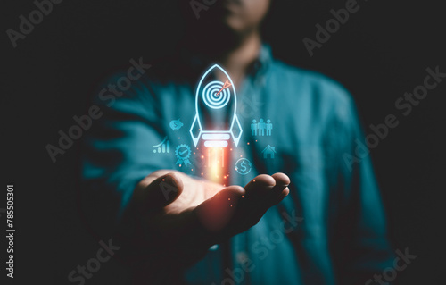 Businessman holding rising of missile rocket with dartboard with arrow for enhance and achieve business objective target and goal concept.