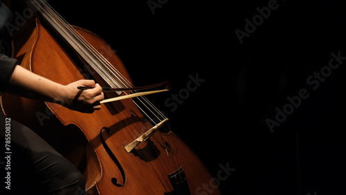 cellist playing cello under spotlight
