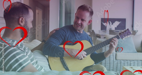 Image of heart icons over diverse gay couple smiling and playing guitar