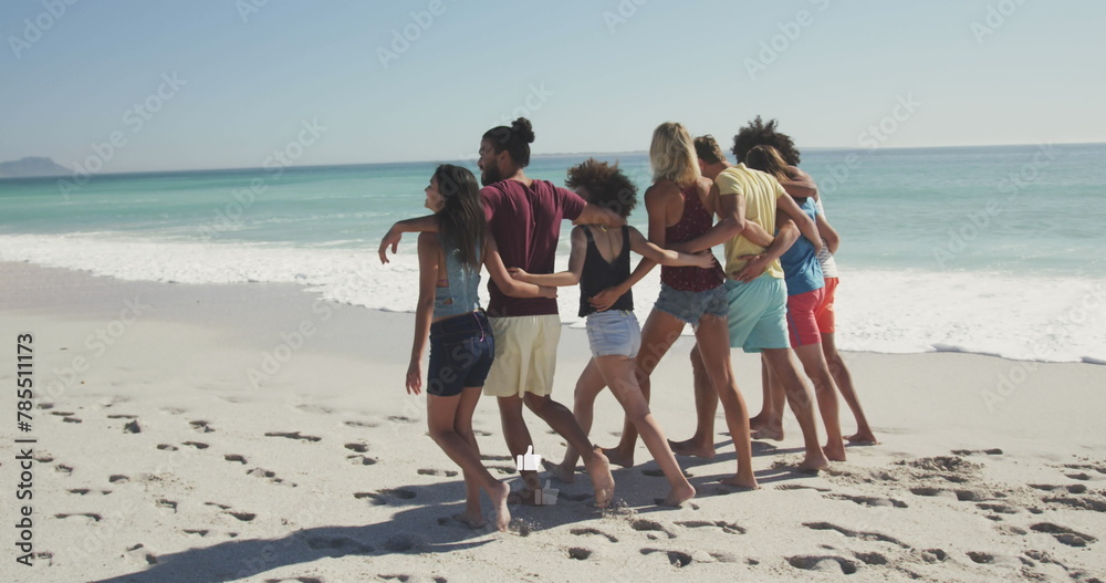 Fototapeta premium Image of american flag over diverse group of friends at beach