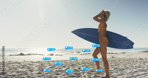 Image of social media reactions over happy caucasian woman with surfboard walking on beach