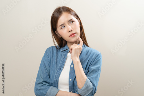 Fotografía Thoughtful Young woman frowning her eyebrows holding index finger on chin having doubt and suspicion feeling sceptical about something