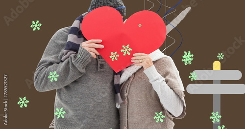 Image of caucasian couple with heart over snow falling