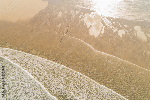 two people on the shore of a beach during low tide, aerial view with drone. Summer holidays concept