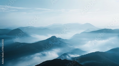 Hushed view of a mountain vista, with fog-covered peaks and sprawling valleys devoid of any human interference 01 © Maelgoa