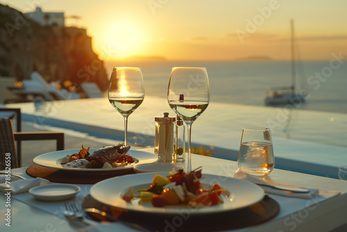 Romantic dinner setup with wine at sunset overlooking the sea.