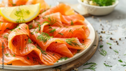  A cutting board holds a smoked salmon plate, garnished with a lemon wedge and fresh dill A separate bowl sits next to it, filled with additional dill for serving