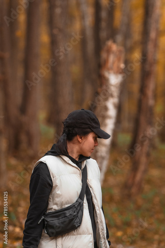 woman with basket looking for mushrooms in autumn forest