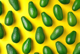 Ripe avocados arranged on a vibrant yellow background in a top view flat lay composition for food photography or recipe concept