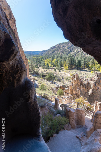 Bandelier National Monument preserves Ancestral Puebloan homes in New Mexico. View from Cavate dwelling in tuff cliff of Tuffs, Frijoles Canyon, Cottonwood trees in autumn, Pueblo loop trail. photo