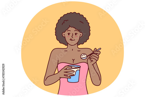 African American woman eating ice cream enjoying cold dessert to cool down after hot walk. Curly ethnic girl with ice cream satisfies hunger and licks lips wanting to be refreshed in summer weather