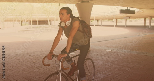 Image of biracial man cycling in city