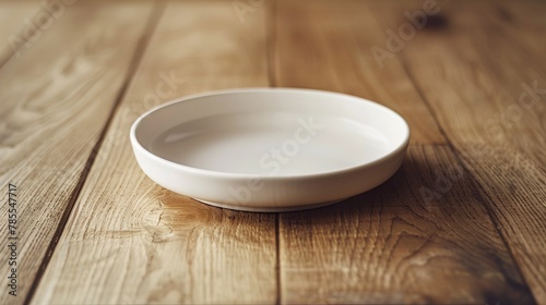 A white ceramic plate on a light wood table with a minimalist centerpiece, focusing on geometry and symmetry in table setting