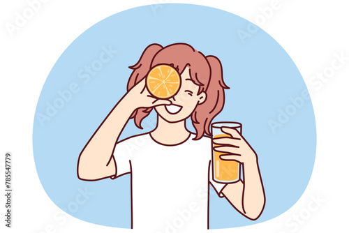 Little girl with glass of orange juice in hands smiling holding half of citrus fruit near face. Happy teenager recommends using orange juice containing healthy vitamins for immunity and health