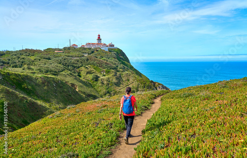 nice woman hiking on the rocky cliffs of Cabo da Roca at the Atlantic coast of Portugal, Europe photo