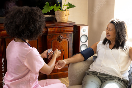 Biracial young woman checking blood pressure of mature mother at home © wavebreak3